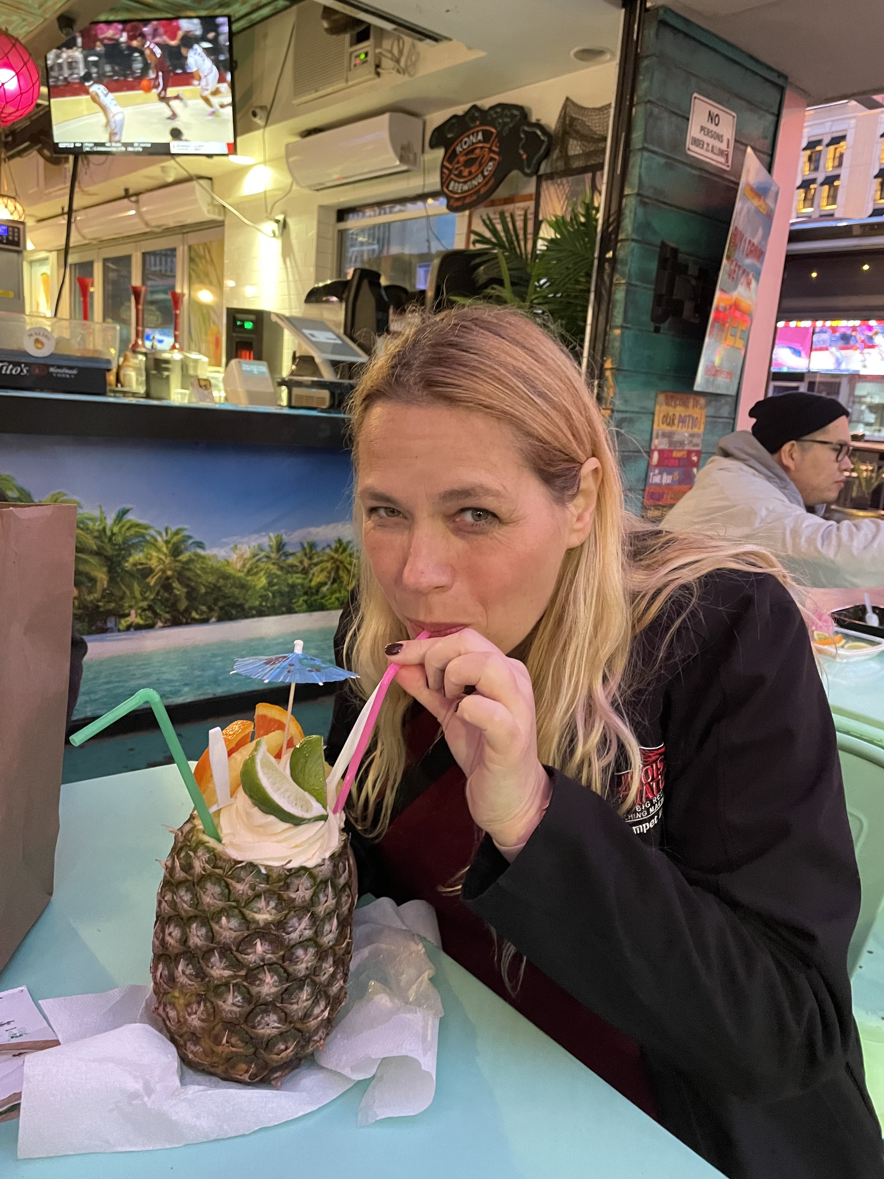 Mari drinking from a pineapple